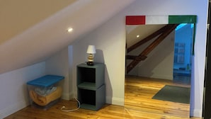 A room with a wooden floor, a blue storage bin, a grey shelf unit, and a lamp. - Charming house with a pool and private, enclosed parking near downtown Bergerac (Bergerac)
