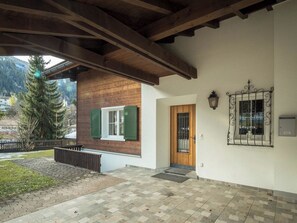 A covered outdoor area with a wooden structure, a door, and a window with a metal frame. - Haus Wick Ferienhaus, Dusche oder Bad, WC Chalet/Ferienhaus by Interhome (Klosters)
