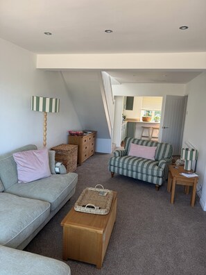 Ein Loft-Wohnraum mit hohen Decken, einer Treppe, einer Küchenzeile und einem großen Fenster.