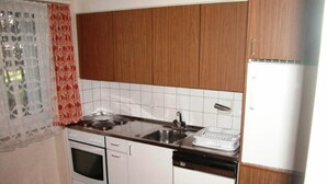Cozinha com armários de madeira, pia, fogão e máquina de lavar louça.