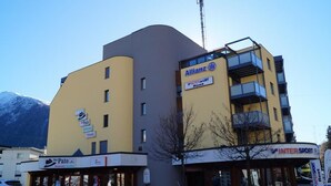 A multi-story building with a sign for 'Allianz InterSport Rent' and a smaller sign for 'Der Pate.' - Touring 307 Appartement/Fewo, Dusche oder Bad, WC 1-Zimmerwohnung by Interhome (Davos)