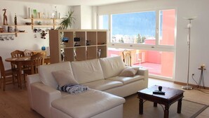 Ein Wohnzimmer mit Sofa, Couchtisch und Bücherregal.