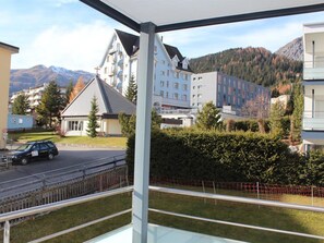 A residential building with a balcony, a road with a car, and mountains in the background. - Mon Repos (BO) Appartement/Fewo, Dusche oder Bad, WC 2½-Zimmerwohnung by Interhome (Davos)