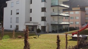 Un immeuble à plusieurs étages, doté d’un toit plat, d’un balcon à l’étage supérieur et d’une enseigne portant le numéro « 57C », indiquant le numéro d’une chambre ou d’un appartement.