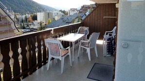 A balcony with a table and chairs, overlooking a mountainous area with buildings. - Efeu 201 Appartement/Fewo, Dusche oder Bad, WC 3½-Zimmerwohnung by Interhome (Davos)