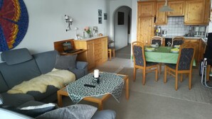 A living room with a sofa, a coffee table, and a dining area with a table and chairs. - Efeu 201 Appartement/Fewo, Dusche oder Bad, WC 3½-Zimmerwohnung by Interhome (Davos)