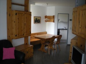 A compact living space with a dining area, kitchenette, and wooden cabinets. - Parsennresidenz 305 Appartement/Fewo, Dusche oder Bad, WC 2½-Zimmerwohnung by Interhome (Davos)
