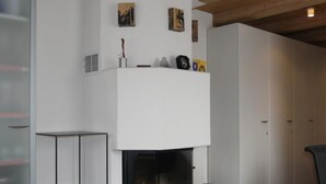 A modern living room with a fireplace, a glass table, and a red rug. - Rex 45 Appartement/Fewo, Dusche oder Bad, WC 2-Zimmerwohnung by Interhome (Davos)