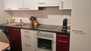 A kitchen with white cabinets, a stainless steel sink, a built-in oven, and a coffee maker. - Talstrasse 22 App 26 Appartement/Fewo, Dusche oder Bad, WC 2½-Zimmerwohnung by Interhome (Davos)