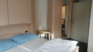 A bedroom with a bed, a wardrobe, and a small table. - Talstrasse 22 App 26 Appartement/Fewo, Dusche oder Bad, WC 2½-Zimmerwohnung by Interhome (Davos)