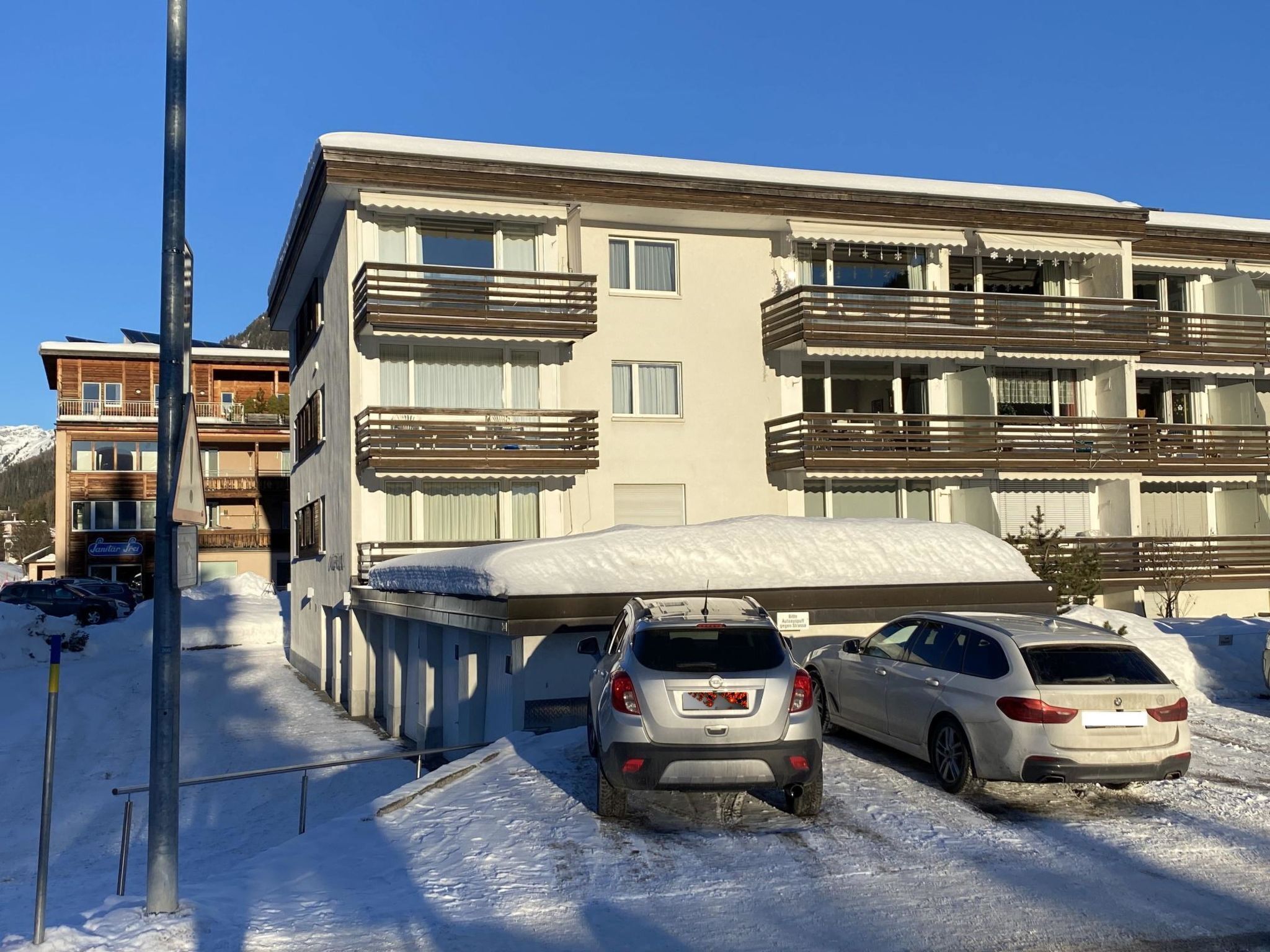 A multi-story building with balconies, a covered parking area, and a sign for 'Santer Spa.'