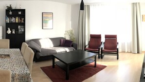 A modern living room with a sofa, two armchairs, a coffee table, and a bookshelf. - Talstrasse 22 App 13 Appartement/Fewo, Dusche oder Bad, WC 3½-Zimmerwohnung by Interhome (Davos)