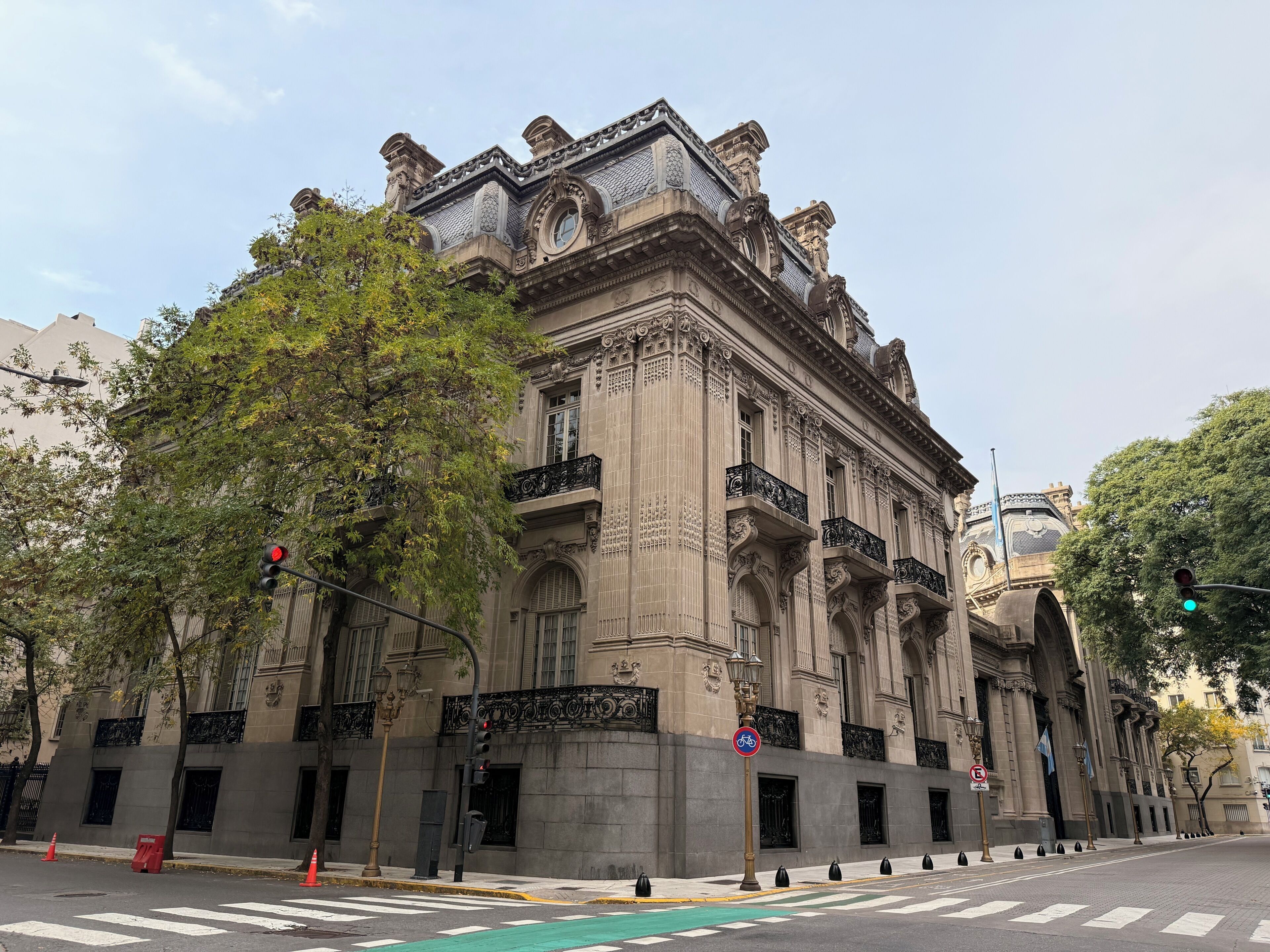 Um edifício histórico com arquitetura elaborada, janelas amplas e uma entrada imponente.