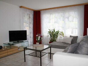 A living room with a TV, glass coffee table, sofa, and a welcome sign. - Talstrasse 22 App 34 Appartement/Fewo, Dusche oder Bad, WC 2½-Zimmerwohnung by Interhome (Davos)