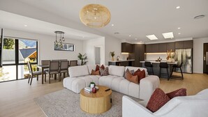 Una sala moderna con un sofá modular, una mesa de centro redonda y un comedor con vistas.