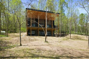 A modern two-story building surrounded by trees in a forested area.