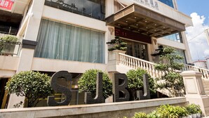 Un hotel de varios pisos con una entrada destacada, grandes ventanales y una zona con balcones.