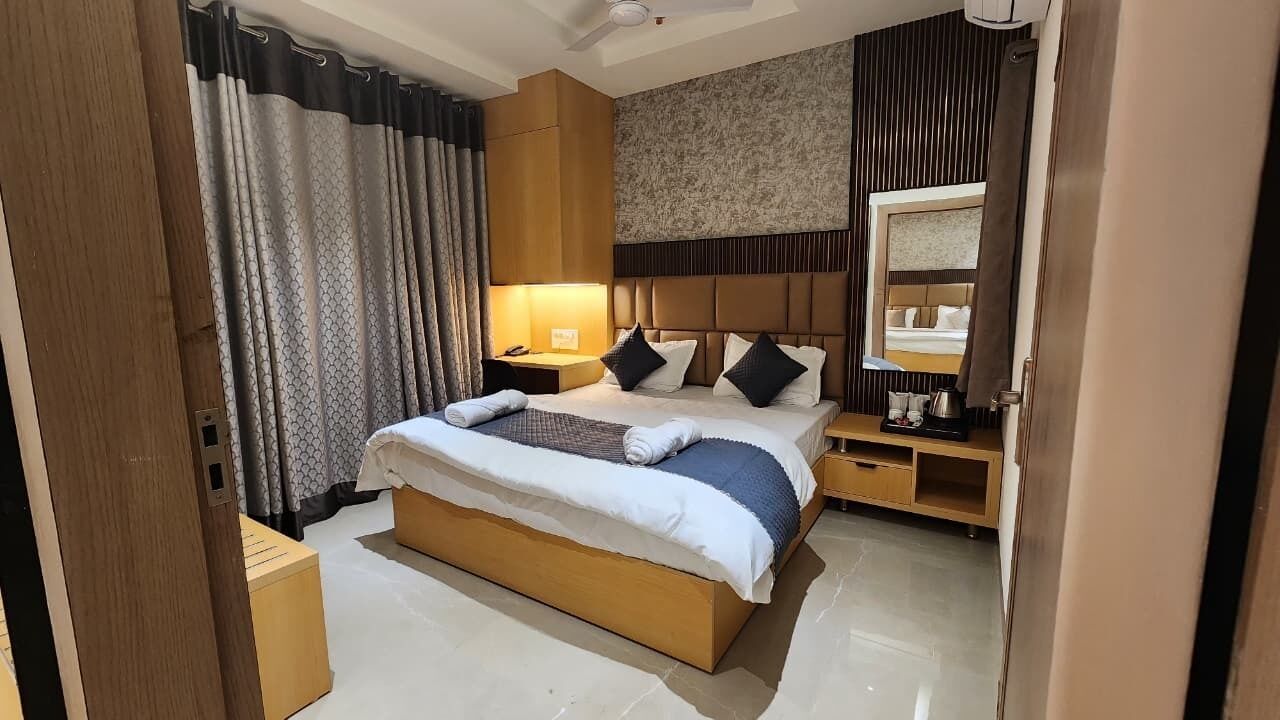 Ein Hotelzimmer mit einem großen Bett, Nachttischen, einem Spiegel und einem Kleiderschrank.