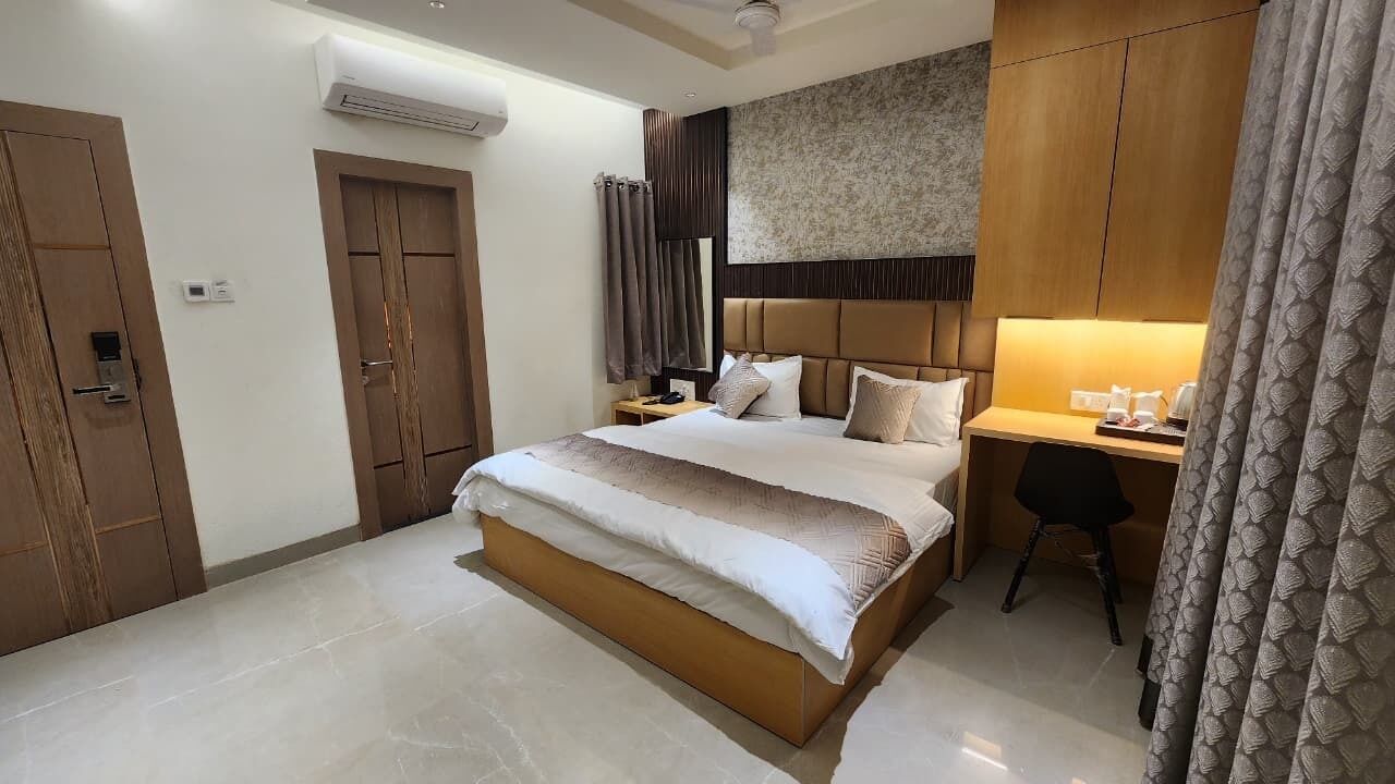Een moderne hotelkamer met een groot bed, een bureau en een kledingkast.