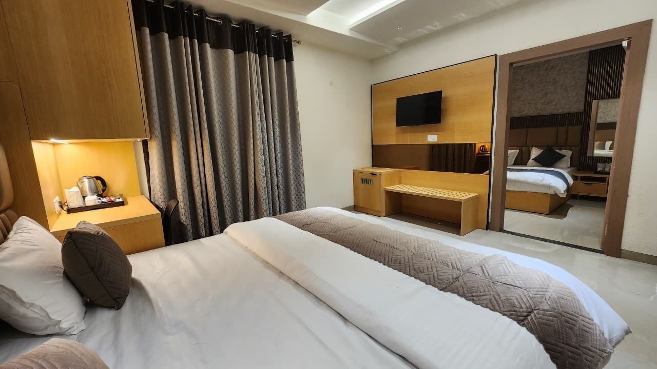 A hotel room with a bed, a desk, a TV, and a sliding door leading to a bathroom.