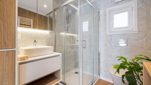 A modern bathroom with a glass-enclosed shower, a white sink, and a wooden vanity. - Studios an der Alten Post (Maxhütte-Haidhof)