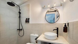 A modern bathroom with a shower, toilet, sink, and a mirror. - Malethonas Cottage by All About Paxos (Paxos)