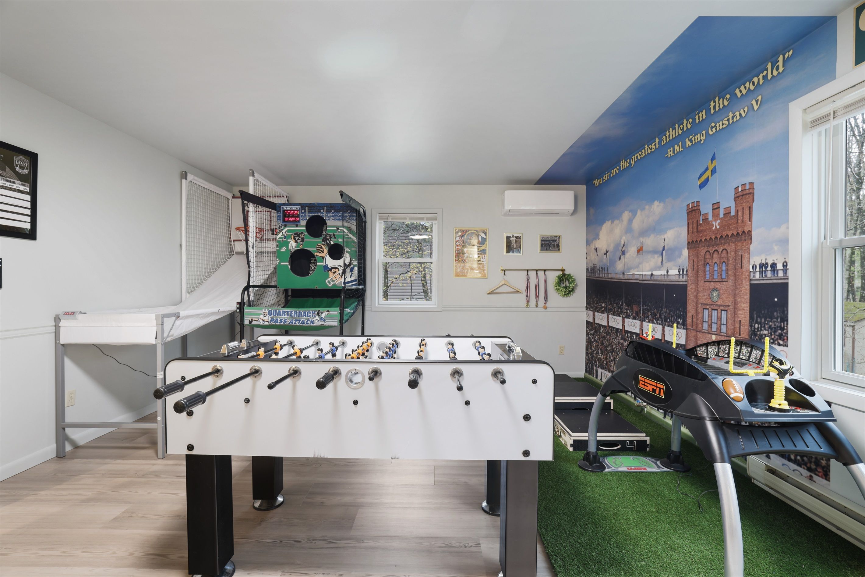 A foosball table, a window with a view, and a mural with a quote and flags.