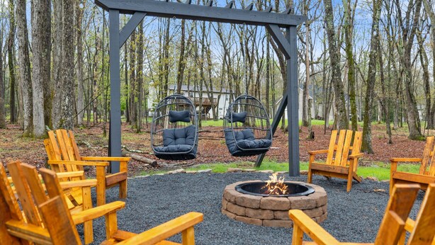 A wooden deck with chairs and a fire pit.