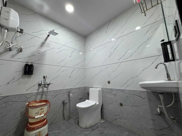 Une salle de bain avec des toilettes, une douche et un lavabo.