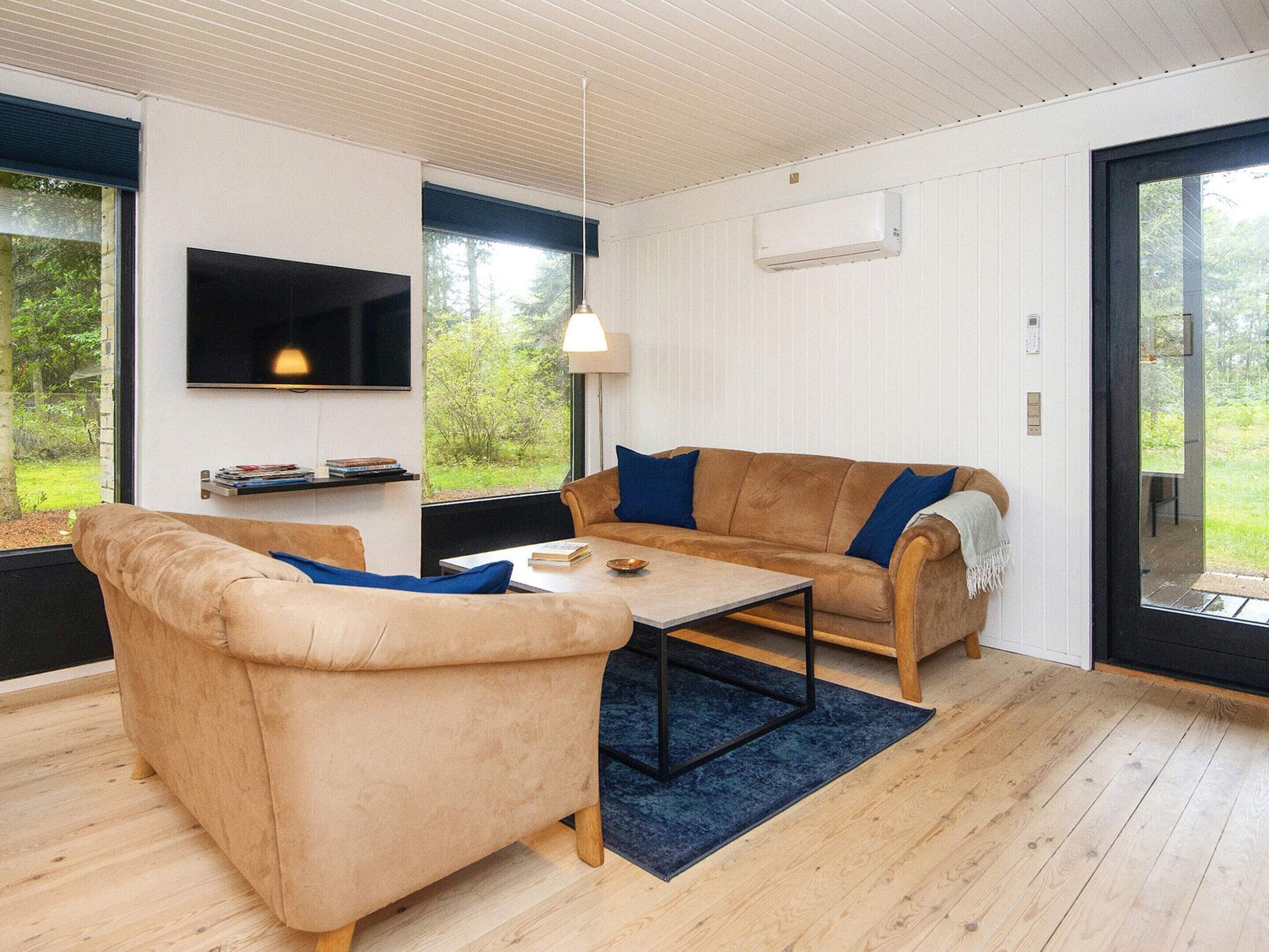 Una sala de estar moderna con un sofá, un sillón y una mesa de centro.