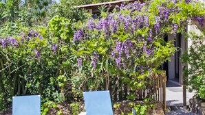 A garden with two lounge chairs and a pergola covered with purple flowers. - "La Cigale" mit Schwimmbad by Interhome (Les Arcs sur Argens)