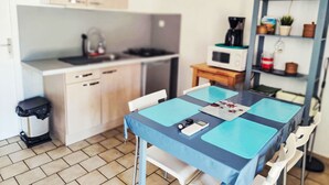 A compact kitchen with a microwave, kettle, and a small table with blue placemats. - "La Cigale" mit Schwimmbad by Interhome (Les Arcs sur Argens)