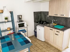 Une cuisine compacte équipée d’un four à micro-ondes, d’une machine à café et d’un petit réfrigérateur.