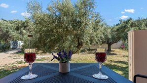 A table with two wine glasses and a potted plant. - Robin's | Red suite (Lefkada)