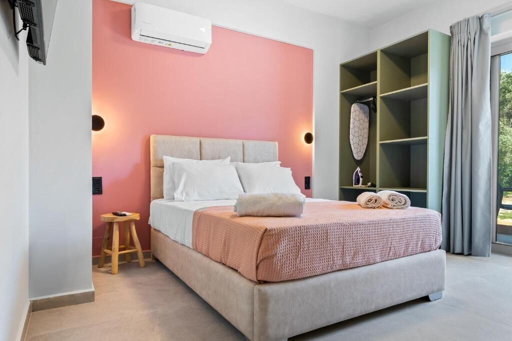 Une chambre à coucher comprenant un lit, un tabouret, une armoire et un appareil de climatisation.