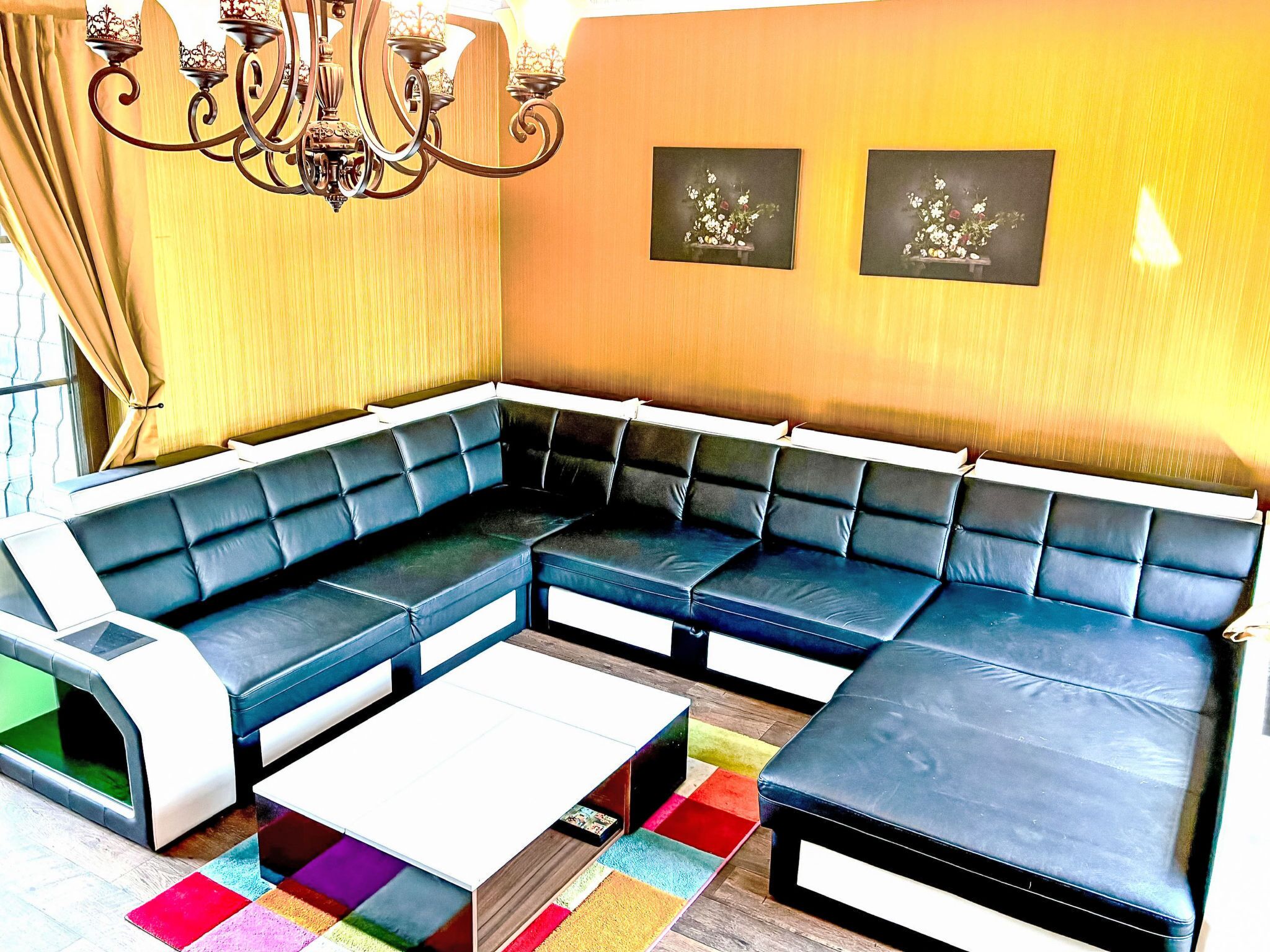 A modern living room with a sectional sofa, a coffee table, and a colorful rug.