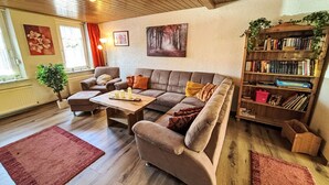 Un salon confortable avec un canapé, une table basse et une bibliothèque.