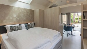 A modern bedroom with a large bed, a skylight, and a view of the outdoors. - Lepelaar by Interhome (Domburg)
