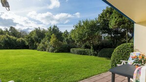 A patio with a lawn, a table, and two chairs. - Duingras by Interhome (Vlissingen)