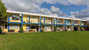 A multi-story motel with a flat roof, balconies, and a well-maintained lawn. - Duingras by Interhome (Vlissingen)