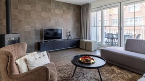 Un salon moderne doté d’une cheminée, d’un téléviseur à écran plat, d’un canapé et d’un balcon avec des meubles d’extérieur.