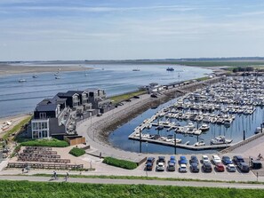Un port de plaisance avec des bateaux, un parking et un bâtiment doté d’un balcon.