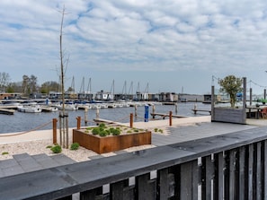 A marina with boats docked, a wooden deck, and a small garden area. - LagoLux Sneekermeer by Interhome (Offingawier)