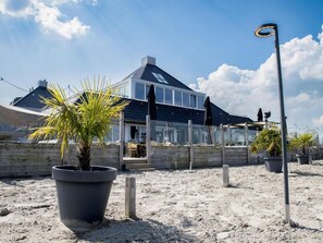 A modern house with a large patio, potted plants, and a street lamp. - LagoLux Sneekermeer by Interhome (Offingawier)