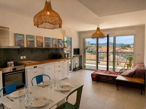 Eine moderne Küche mit Essbereich, großen Fenstern und einem Balkon mit Aussicht.
