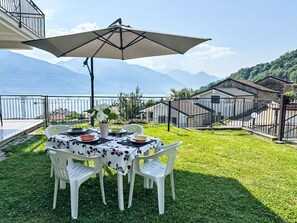 Mesa al aire libre con vistas a montañas, una sombrilla y barandilla.