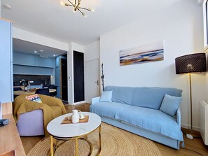 A modern living room with a sofa, coffee table, and a painting on the wall. - Les Pieds dans l'Eau by Interhome (Roscoff)