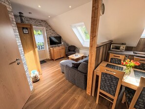 A loft-style room with a loft bed, a television, a sofa, a dining table, and a kitchen area. - Apartment Fecht by Interhome (Marienhafe)