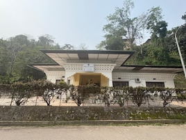 A building with a large overhang, a sign reading 'DELUXE STAY', and a stone wall in the foreground.