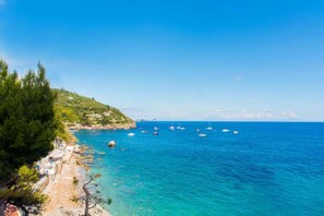 A coastal view with clear blue sea, boats, and a rocky shoreline. - Casa Giovanna B in Nerano (Massa Lubrense)